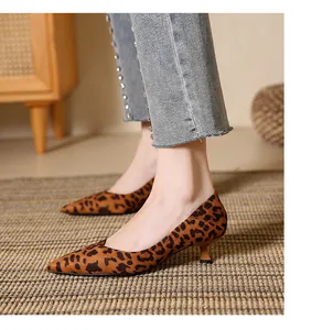 Detail view of stylish leopard print pointed-toe kitten heel pumps worn by model