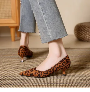 Elegant leopard print suede pointed-toe kitten heels for women shown in a detail view on a rug