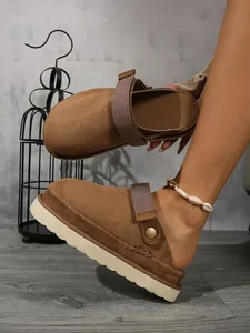 Détail de sabots à plateforme en daim marron avec sangle réglable et semelle épaisse