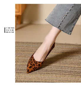 Detail shot of leopard print pointed-toe suede pumps paired with pearl-embellished denim