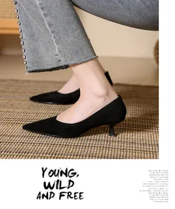 Close-up of black suede pointed-toe kitten heel pumps with elegant minimalist design.