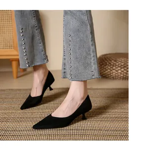 Elegant black suede pointed-toe kitten heel pumps shown in a detailed lifestyle setting