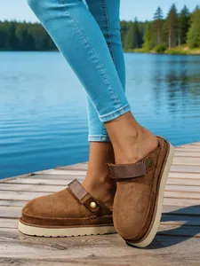 Sabots à plateforme en daim marron pour femmes avec jean sur un ponton en bois au lac