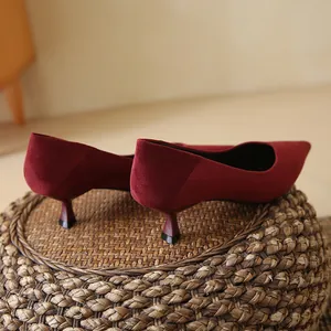 Elegant wine red suede pumps featuring a sharp pointed toe and a stylish kitten heel design.