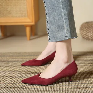 Detailed side view of elegant wine red suede pointed-toe pumps featuring kitten heels