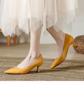 Détail d'élégants escarpins jaunes à bouts pointus et talons aiguilles en cuir