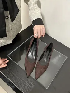 Close-up of elegant dark brown suede pointed toe pumps with slim middle heels