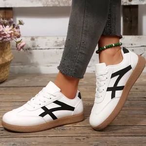 Vue de côté de baskets T-trainer vintage pour femmes en blanc avec des bandes noires