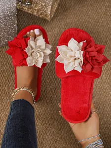Vista macro di pantofole rosse in peluche con eleganti fiori di stoffa e consistenza