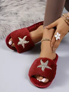 Dettaglio pantofole in peluche rosse con decorazione a stella marina in strass