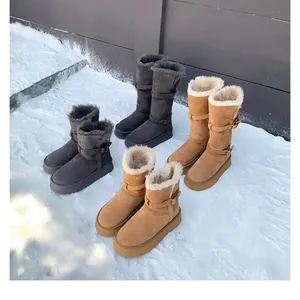 Variety of women's thick-soled snow boots in tan and grey colors on fresh snow.