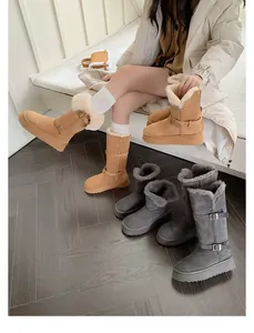 Detailed view of tall platform snow boots in camel and grey with warm fur lining.
