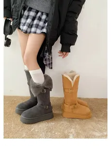 Detail of thick-soled tall snow boots with faux fur trim and buckle straps.