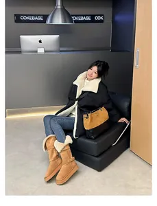 Woman wearing tall tan platform snow boots with fleece lining in a stylish indoor setting