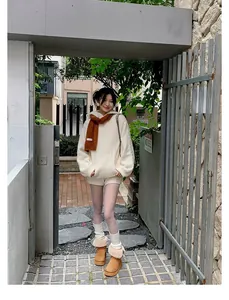 Outdoor full-body shot of a model wearing platform snow boots with stylish fur trim