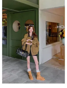 Stylish woman wearing tan thick-soled snow boots with warm white fuzzy lining for winter