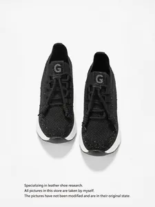 Gros plan sur des baskets noires respirantes à strass avec semelles compensées.