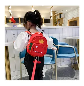 Vista detallada de la mochila roja de dinosaurio para niños con correa de seguridad