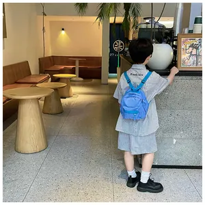 Vue détaillée de dos d'un enfant portant le sac à dos de maternelle bleu ciel tendance