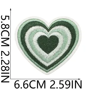 Detail eines grünen Herz-Stickpatches mit Maßen von 5,8 cm x 6,6 cm auf weißem Grund.