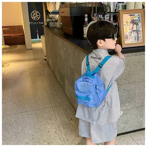 Vue détaillée d'un sac à dos bleu pour enfant porté par un petit garçon