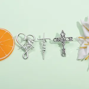 Detailed view of silver metallic pins featuring Faith and Amazing Grace religious designs