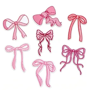 Macro view of various pink embroidered bow patches with detailed stitching