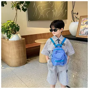 Sac à dos bleu léger pour enfants avec un design gaufré tendance sur un petit garçon
