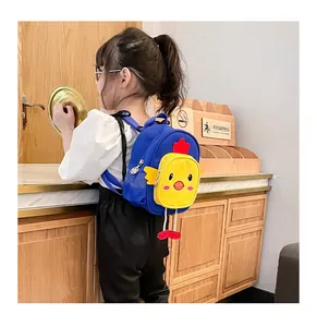 Vista detallada de una mochila azul con diseño de pollito de dibujos usada por una niña