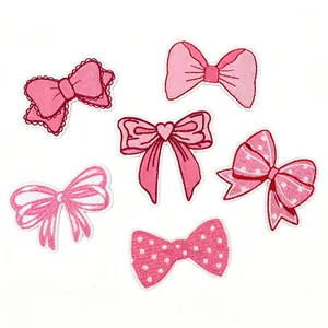 Detailed view of six different styles of pink embroidered bow patches for clothing