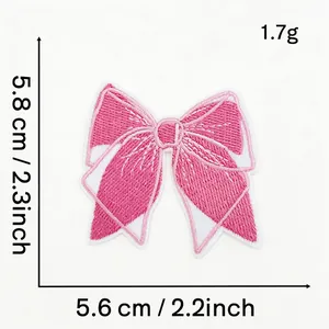 Macro detail of pink bow embroidery patch showing exact dimensions 5.6cm by 5.8cm