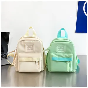 Vue détaillée montrant des sacs à dos pour enfants en beige et vert menthe avec logo