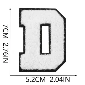 Dettaglio della toppa ricamata lettera D in ciniglia bianca con dimensioni 7cm x 5,2cm