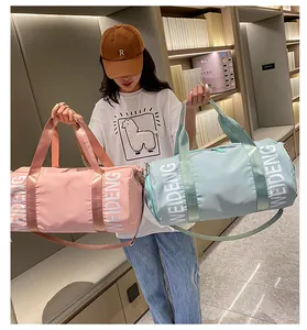 Grande borsa sportiva cilindrica da donna in rosa e blu presentata da una modella