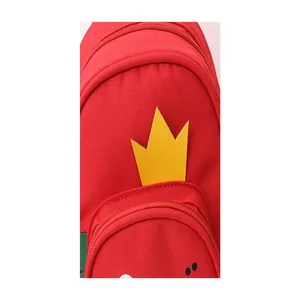 Detalle del diseño de corona amarilla en la mochila roja de lona para niños