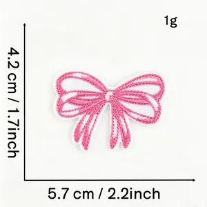 Detailed view of a pink embroidered bow patch showing precise measurement markers