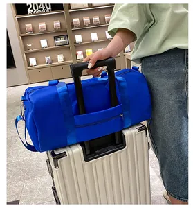 Borsa sportiva blu di grande capacità montata sul manico di una valigia argento