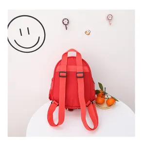 Vista trasera de una mochila roja para niños con correas ajustables y asa superior.
