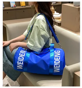Vista dettagliata di una grande borsa da palestra cilindrica blu con logo WEIDENG portata da modella