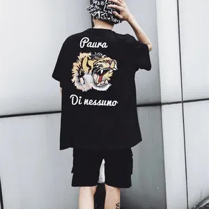 Streetwear black oversized t-shirt with detailed tiger back print and white artistic text.