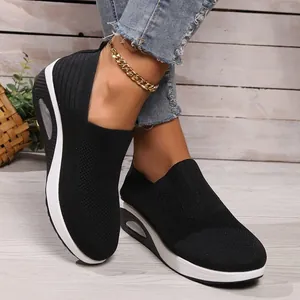 Detailed shot of black fly-knit platform sneakers with comfortable air cushion sole