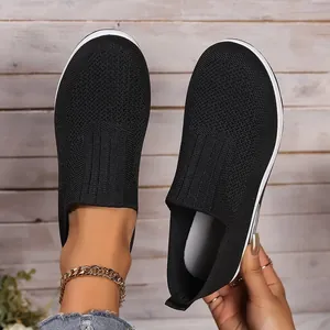 Close-up of black breathable fly-knit texture on comfortable slip-on women's sneakers