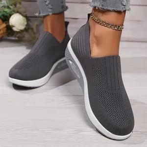 Detail view of grey breathable flyknit slip-on sneakers with platform air cushion sole