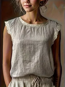 Dettaglio di una camicetta beige senza maniche in cotone e lino con pizzo elegante