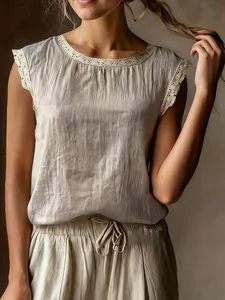 Dettaglio di una blusa senza maniche in lino con pizzo e una vestibilità rilassata.