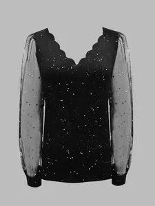 Detailed close-up of a black V-neck top featuring sheer celestial star mesh sleeves