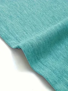 Gedetailleerde macro-opname van hoogwaardige dubbele stiksels op groenblauwe gebreide T-shirtstof
