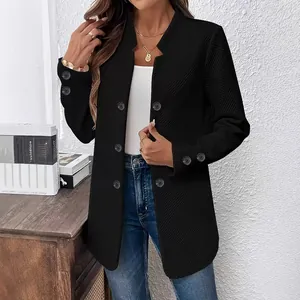 Detailopname van zwarte getextureerde blazer met sierknopen en geribbeld patroon.