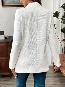 Gedetailleerd achteraanzicht van witte blazer met reliëf en uniek geometrisch patroon