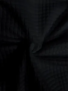 Detailopname van zwarte gewatteerde wafeltextuurstof voor een casual damesjack met capuchon